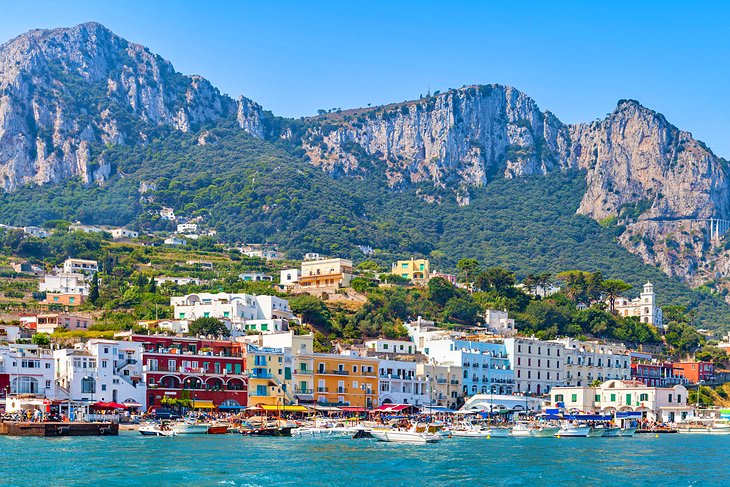 Colorful and sunny sea-side town in Italy, nestled against the edge of the ocean's sun-pierced turqoise waters.